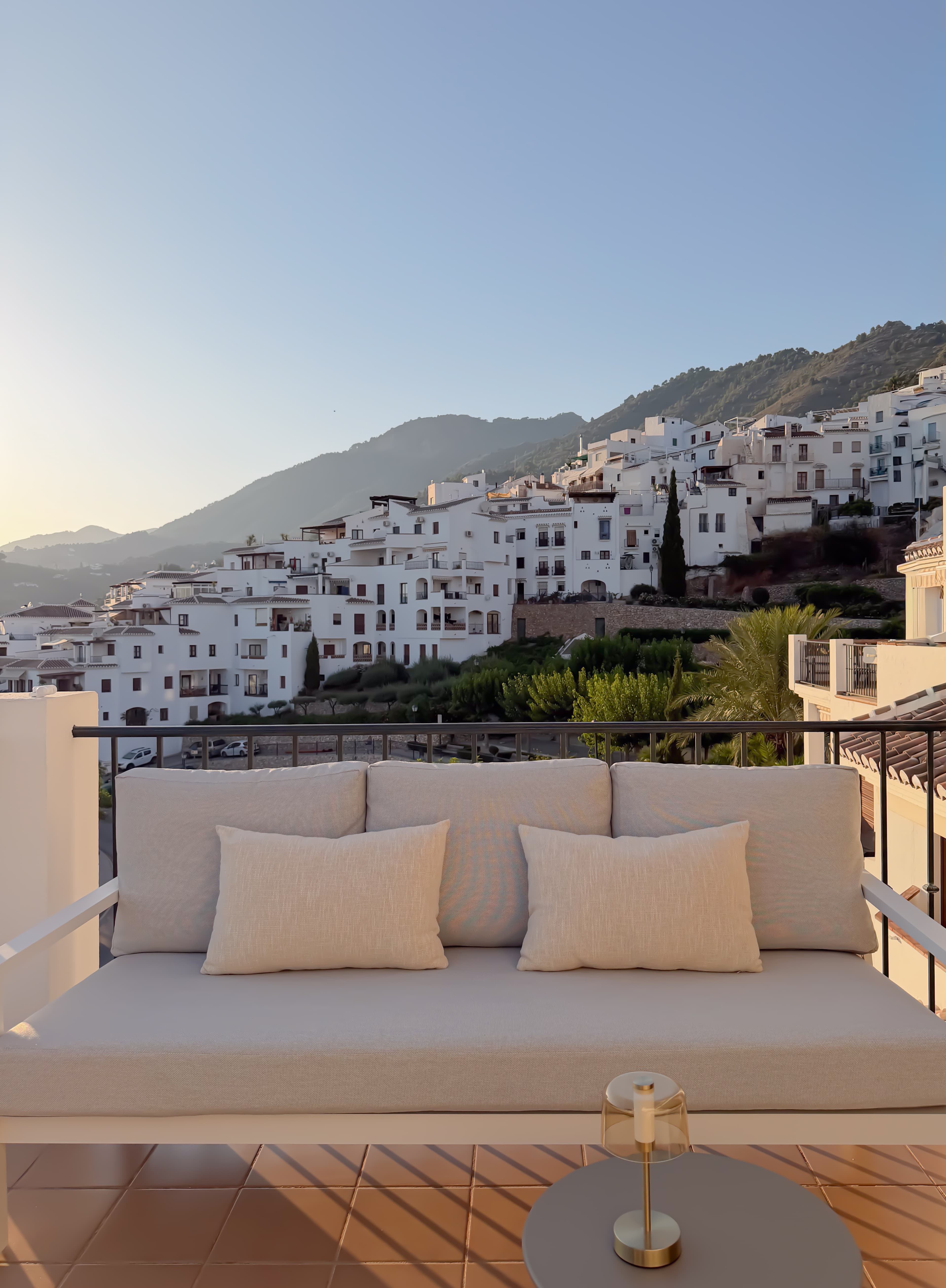 Terrace sofa overlooking the whitewashed hillside village of Frigiliana at sunset
