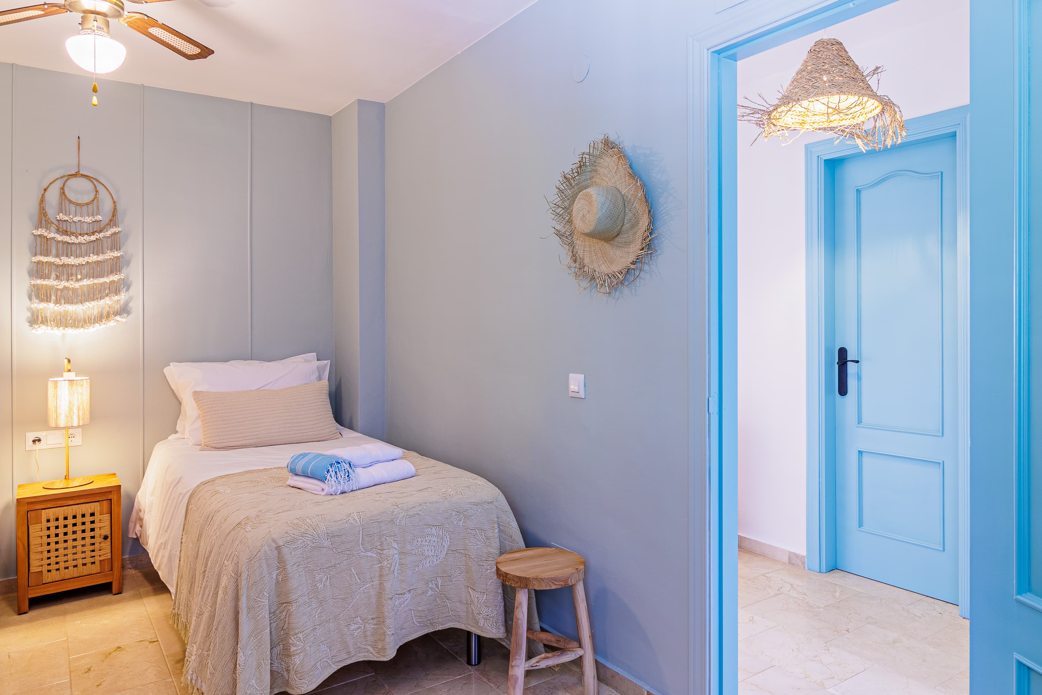 Bedroom corner with a built-in wardrobe, curtained window, and a woven pendant lamp