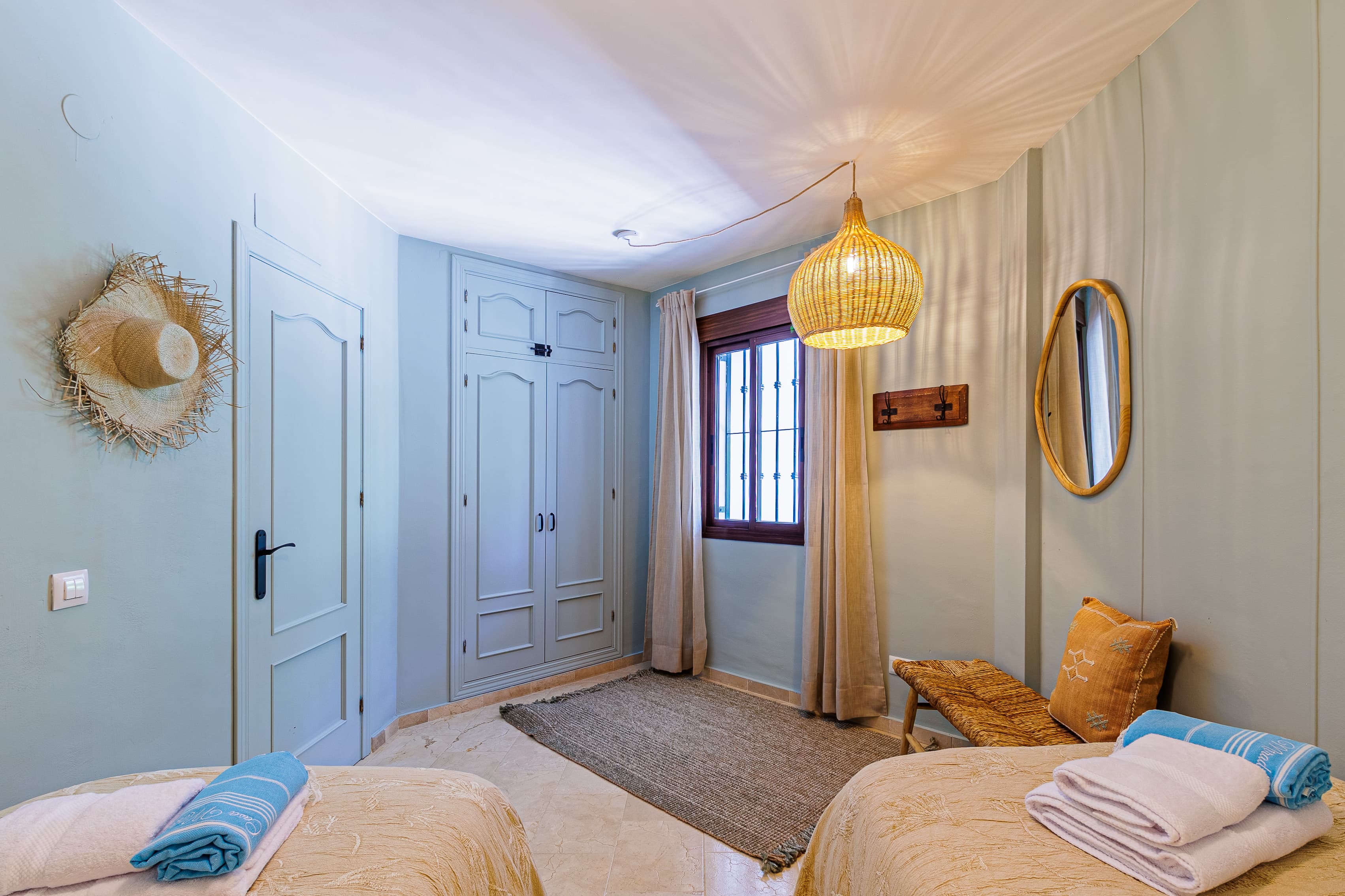 Bedroom with a paneled door, built-in wardrobe, and folded towels on the bed in the foreground
