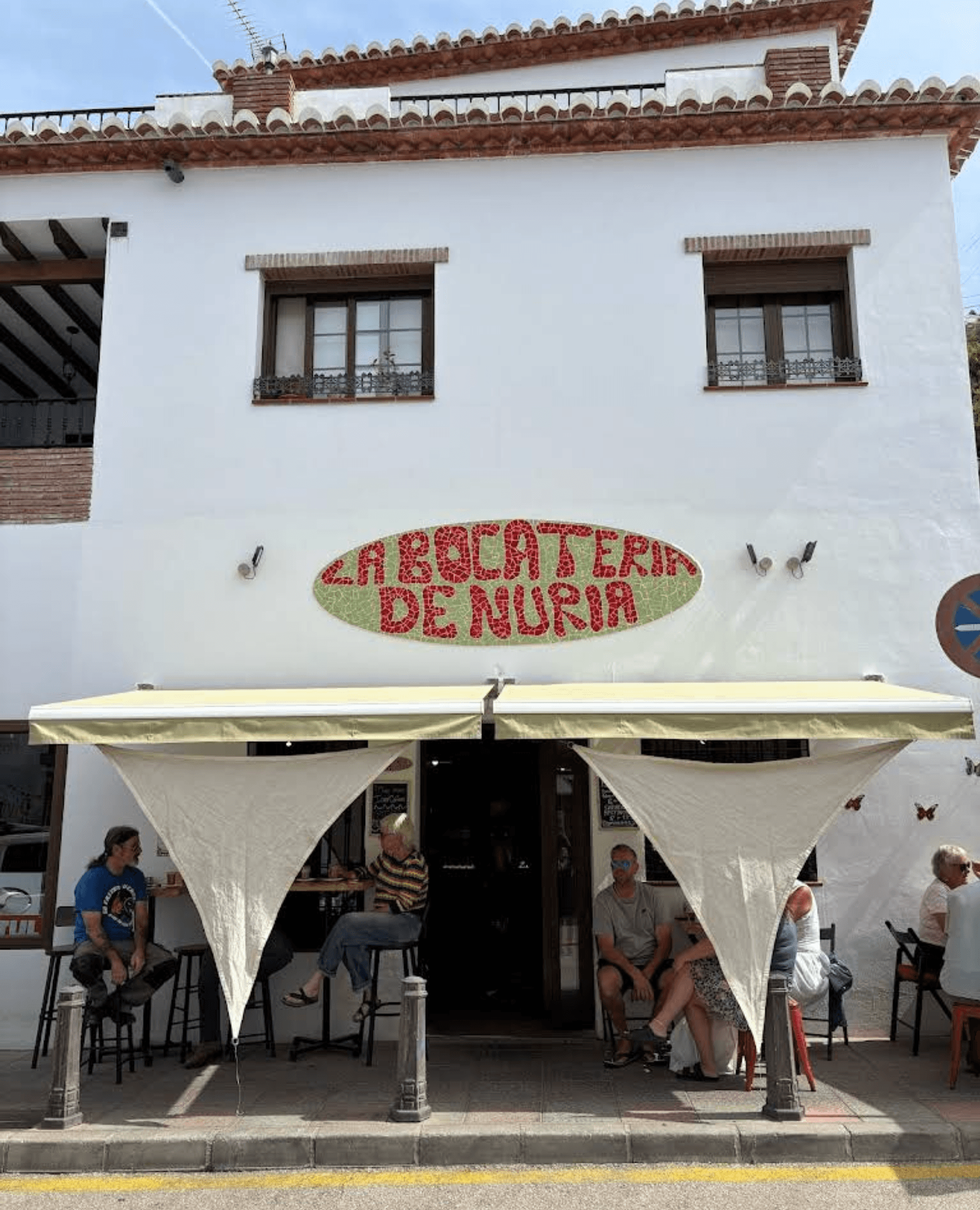 Terrace and mosaic-tile sign of La Bocatería de Nuria in Frigiliana
