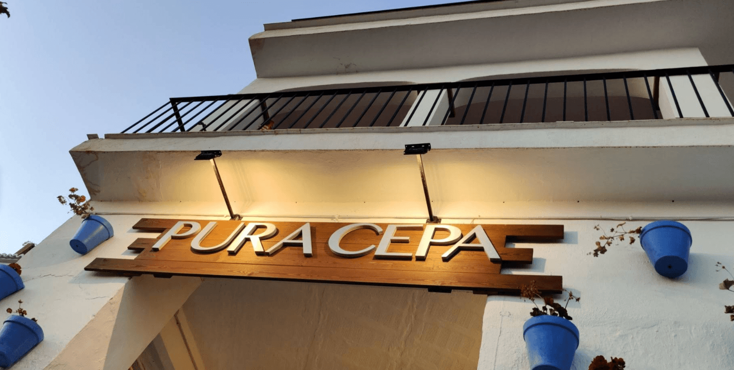 Illuminated sign above the entrance of Pura Cepa in Frigiliana