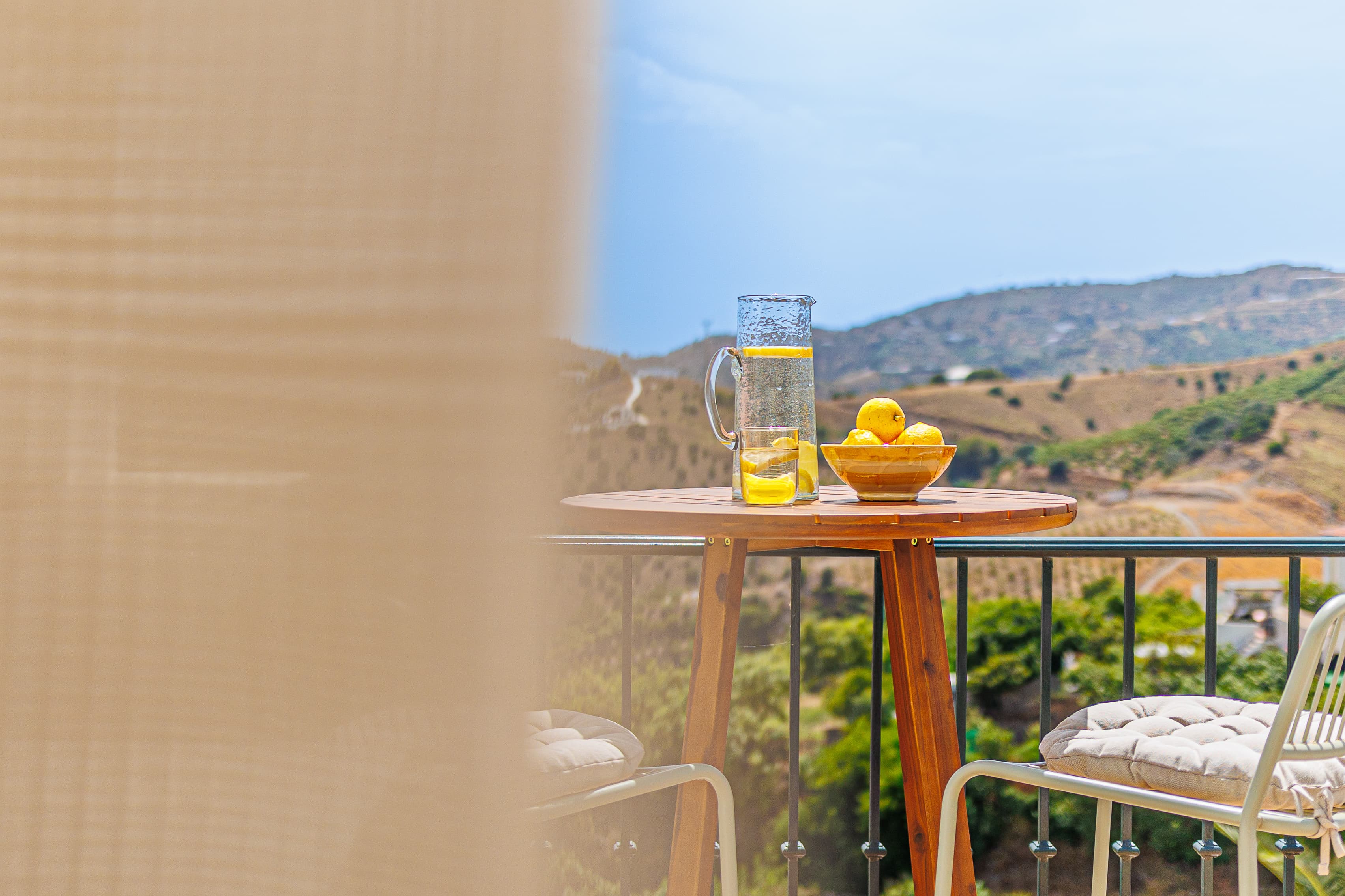 Balcony breakfast table scene, softly blurred curtain in the foreground