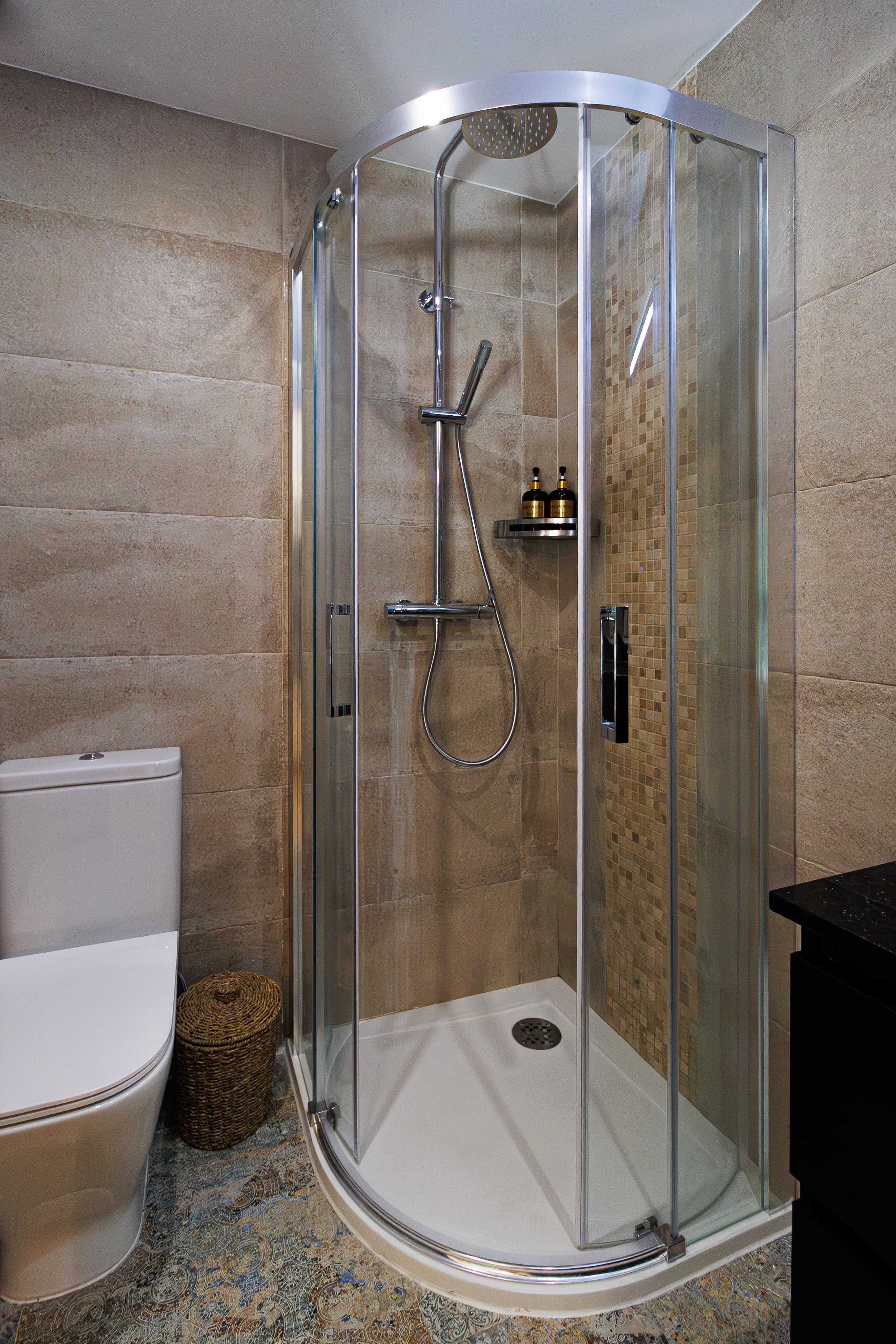 Bathroom detail with a curved glass shower and chrome fixtures