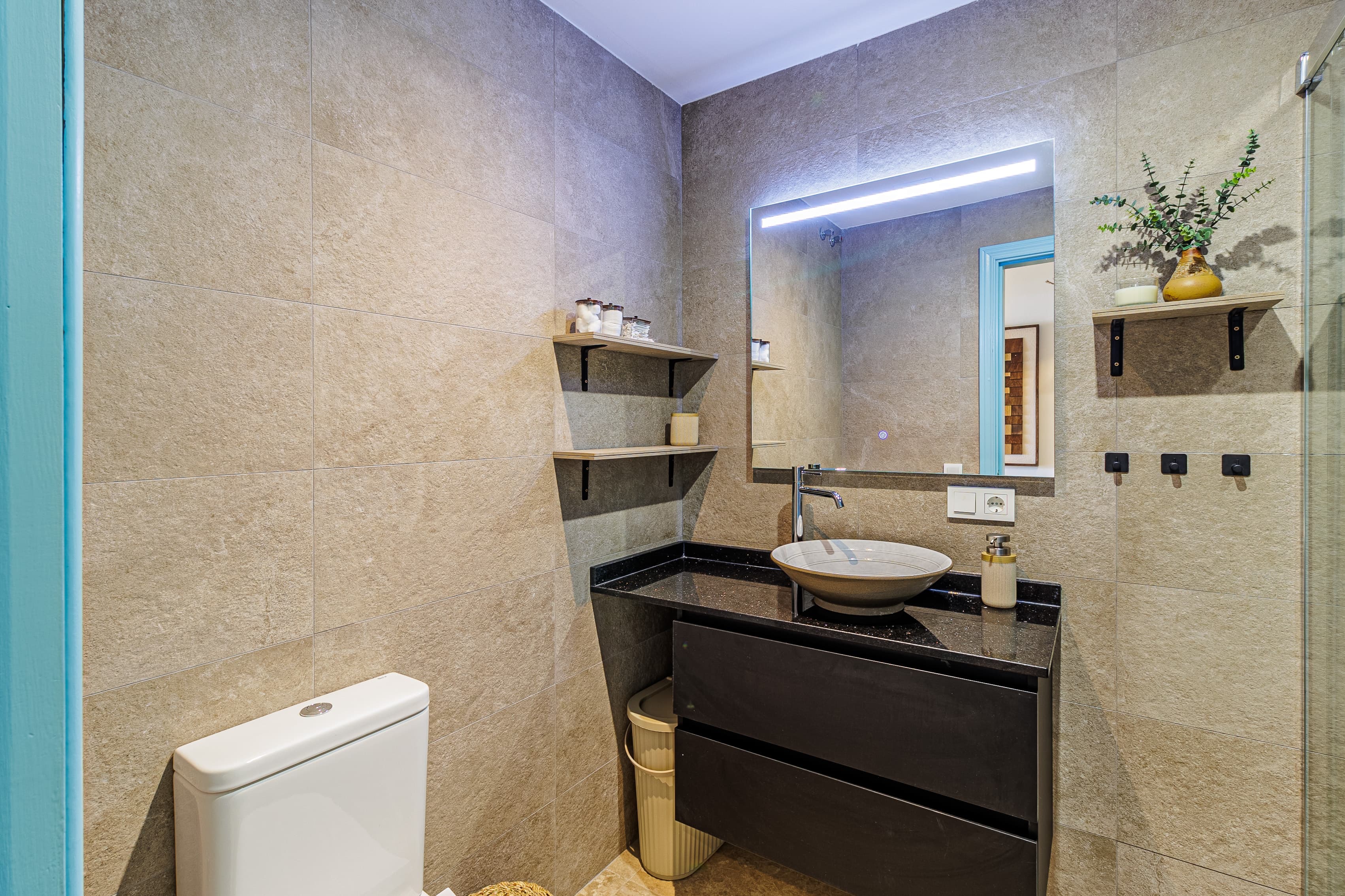 Bathroom with a black stone vanity and round vessel sink